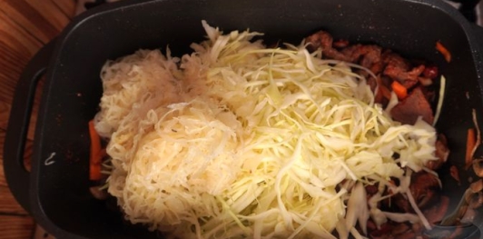 Фото приготовления рецепта: Бигос с говядиной, колбасками, грибами и черносливом - шаг №18