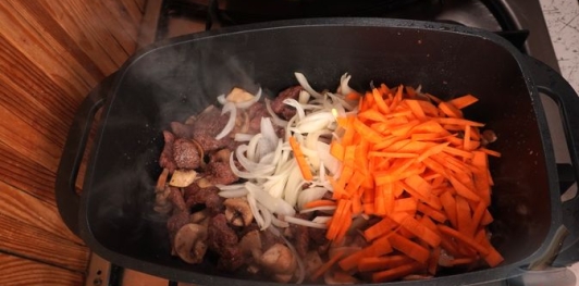 Фото приготовления рецепта: Бигос с говядиной, колбасками, грибами и черносливом - шаг №10