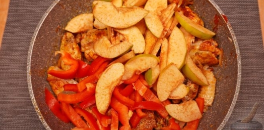 Фото приготовления рецепта: Куриные крылышки, тушенные с айвой и сладким перцем - шаг №10