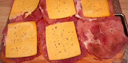 Фото приготовления рецепта: Рулетики из свинины с яйцами, ветчиной, сыром и черемшой - шаг №6