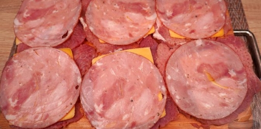 Фото приготовления рецепта: Рулетики из свинины с яйцами, ветчиной, сыром и черемшой - шаг №7