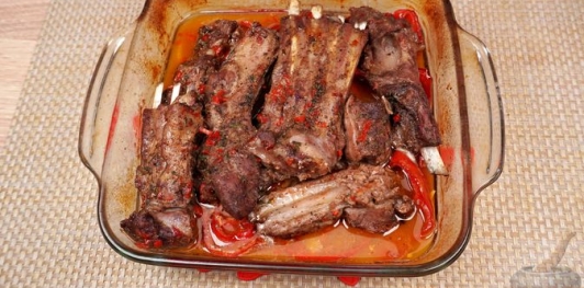 Фото приготовления рецепта: Бараньи рёбрышки, запечённые с помидорами и перцем под острым соусом - шаг №18