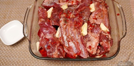 Фото приготовления рецепта: Бараньи рёбрышки, запечённые с помидорами и перцем под острым соусом - шаг №16