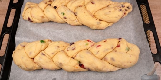 Фото приготовления рецепта: Куличи-косички с изюмом, цукатами, цедрой лимона и глазурью с лепестками миндаля - шаг №26