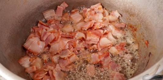 Фото приготовления рецепта: Свинина, тушенная с овощами, беконом и копчёными колбасками (по-дебреценски) - шаг №9