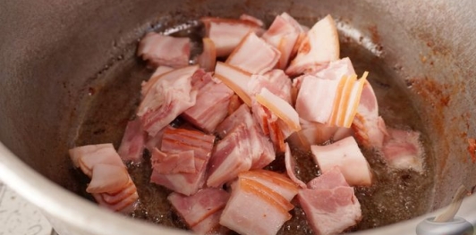 Фото приготовления рецепта: Свинина, тушенная с овощами, беконом и копчёными колбасками (по-дебреценски) - шаг №8