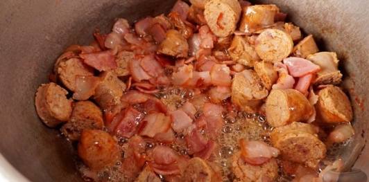 Фото приготовления рецепта: Свинина, тушенная с овощами, беконом и копчёными колбасками (по-дебреценски) - шаг №11