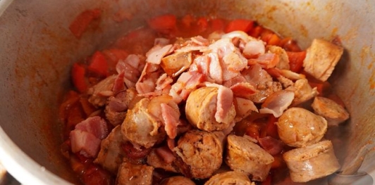 Фото приготовления рецепта: Свинина, тушенная с овощами, беконом и копчёными колбасками (по-дебреценски) - шаг №20