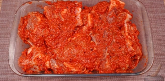 Фото приготовления рецепта: Свиные рёбрышки, запечённые в томатно-яблочном соусе - шаг №11