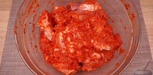 Фото приготовления рецепта: Свиные рёбрышки, запечённые в томатно-яблочном соусе - шаг №10